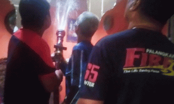 Petugas pemadam kebakaran berupaya memadamkan api yang berada di flapon rumah warga.