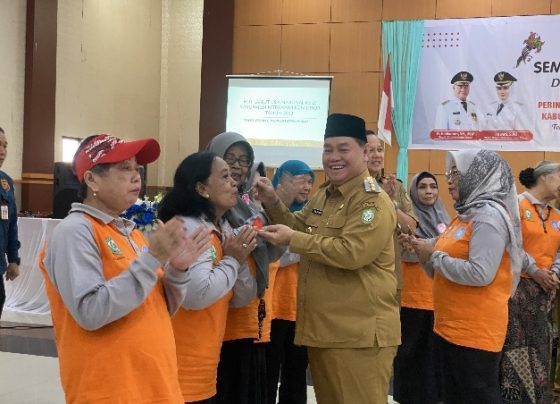 Bupati Kotim Halikinnor didampingi Ketua PKK Kotim Khairiah Halikinnor saat menyuapkan kue kepada salah seorang lansia.