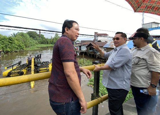 Bupati Kotim Halikinnor (kacamata hitam) melihat uji coba ekskavator ampibi, di nuara Sungai Pamuatan, Sampit, Jumat, 30 Juni 2023.