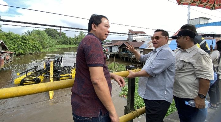 Bupati Kotim Halikinnor (kacamata hitam) melihat uji coba ekskavator ampibi, di nuara Sungai Pamuatan, Sampit, Jumat, 30 Juni 2023.