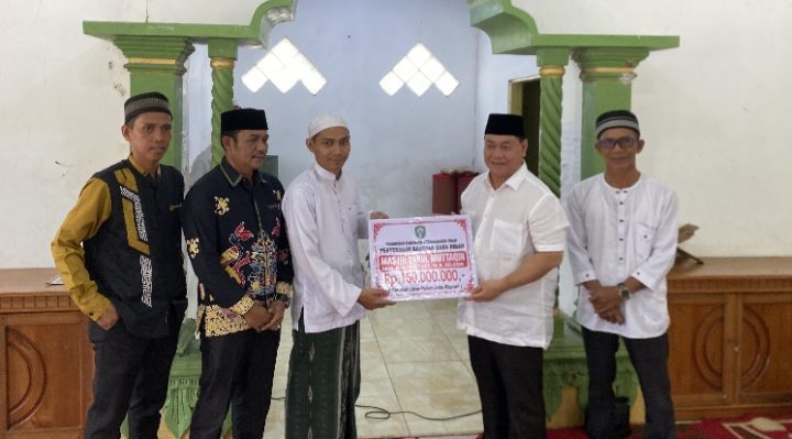 Bupati Kotim Halikinnor saat menyerahkan bantuan dana hibah kepada pengurus Pondok Pesantren Darul Falah Kecamatan Mentaya Hilir Selatan.