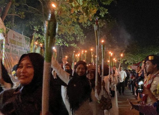 Peserta terlihat gembira sambil memegang obor di tangannya masing masing dalam Pawai Oboro Keliling di Kecamatan Baamang, Rabu, 28 Juni 2023.