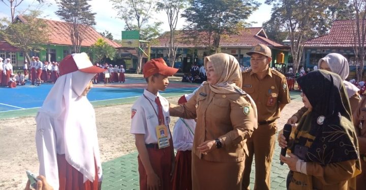 Wakil Bupati Kotim Irawati saat mengenakan tanda pengenal kepada peserta didik baru di SMPN3 Sampit, Senin, 10 Juli 2023.