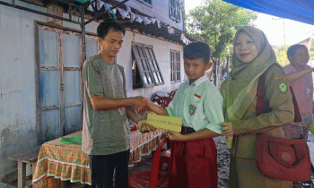 Kepala SDN 3 Kota Besi Hilir, Eka Purdiawati bersama muridnya menyerahkan bantuan kepada korban kebakaran, Selasa, 29 Agustus 2023.