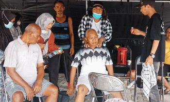 Paman Dakai memijat pasien saat pengobatan alternatif gratis di halaman Kantor Kecamatan Mentawa Baru Ketapang, Rabu, 9 Agustus 2023.