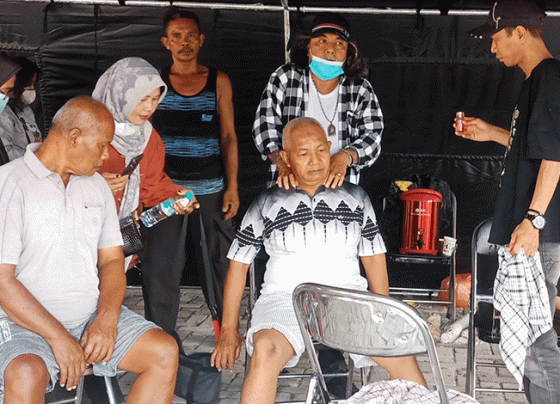 Paman Dakai memijat pasien saat pengobatan alternatif gratis di halaman Kantor Kecamatan Mentawa Baru Ketapang, Rabu, 9 Agustus 2023.