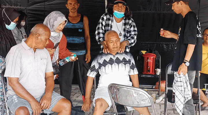Paman Dakai memijat pasien saat pengobatan alternatif gratis di halaman Kantor Kecamatan Mentawa Baru Ketapang, Rabu, 9 Agustus 2023.