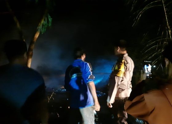 Petugas Polsek Sungai Sampit saat mengidentifikasi rumah warga Desa Bagendang Permai yang terbakar, Minggu malam, 13 Agustus 2023.