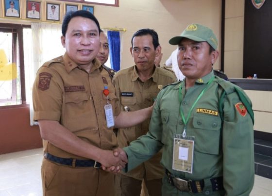 Sekda Kotim Fajrurrahman didampingi Camat Kota Besi Gusti Mukafi berjabat tangan dengan salah seorang anggota Satlinmas, Senin, 14 Agustus 2023.