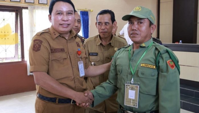 Sekda Kotim Fajrurrahman didampingi Camat Kota Besi Gusti Mukafi berjabat tangan dengan salah seorang anggota Satlinmas, Senin, 14 Agustus 2023.