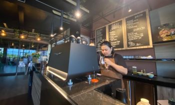 Barista Query sedang mengoperasikan mesin pembuat esspresso.