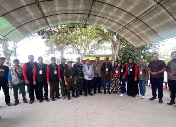 Bupati Kotim Halikinnor saat berfoto bersama dengan para petugas pemungutan suara Pilkades Eka Bahurui Kecamatan MB Ketapang.