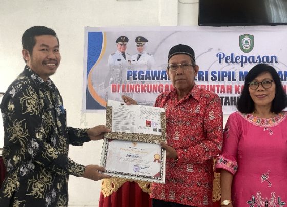 Kepala BKD Kotim Kamaruddin saat menyerahkan piagam serta SK kepada Camat Telaga Antang yang purnatugas.