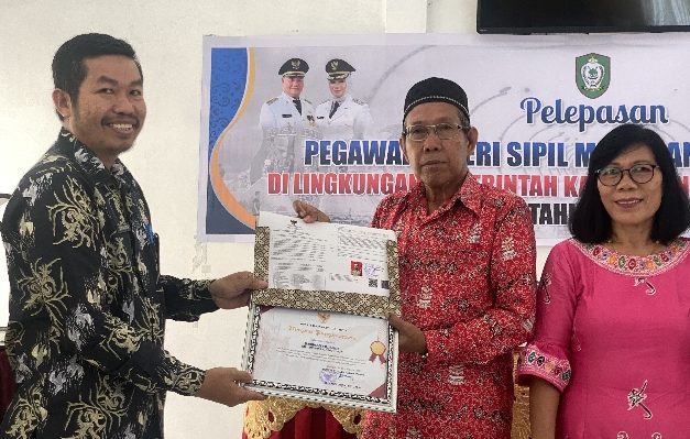 Kepala BKD Kotim Kamaruddin saat menyerahkan piagam serta SK kepada Camat Telaga Antang yang purnatugas.