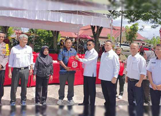 Pj. Bupati Murung Raya Hermon (kecamata hitam) saat menyerahkan secara simbolis paket sembako setelah membuka secara resmi operasi pasar murah di stadion mini Kota Puruk Cahu, Rabu, 25 Oktober 2023.