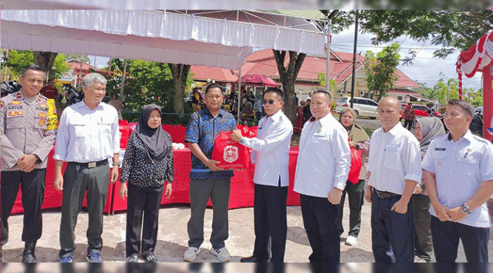 Pj. Bupati Murung Raya Hermon (kecamata hitam) saat menyerahkan secara simbolis paket sembako setelah membuka secara resmi operasi pasar murah di stadion mini Kota Puruk Cahu, Rabu, 25 Oktober 2023.