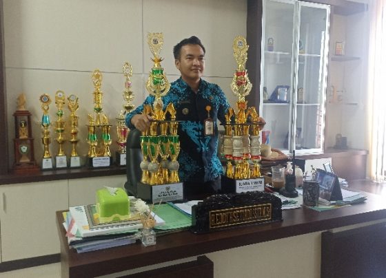 Camat MB Ketapang, Eddy Hidayat Setiadi bersama dua buah piala juara umum FSQ dan MTQ ke 54 Kotim, Kamis 2 November 2023.