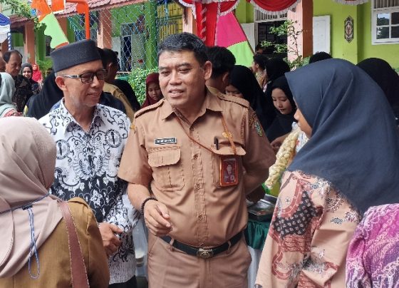 Plt Kadisdik Kotim, M. Irfansyah baju cokelat tengah berbincang dengan warga sekolah.