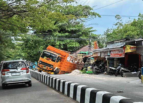 Truk Fuso yang terperosok di perempatan Jalan RA Kartini Pemuda, Senin, 20 November 2023.