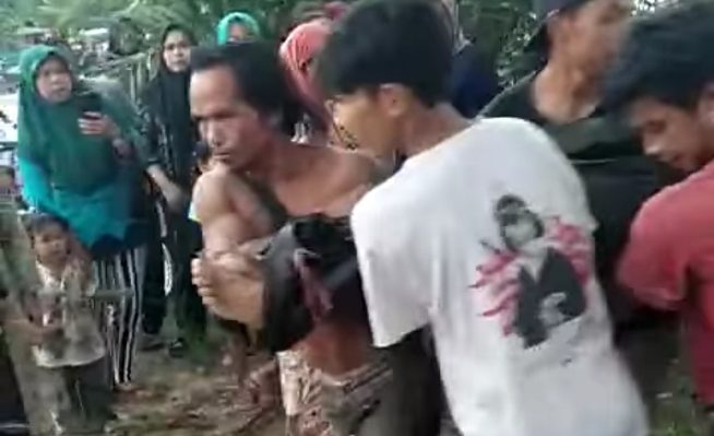 Warga saat mengangkat jasad korban setelah ditemukan tidak bernyawa di sungai Seruyan.