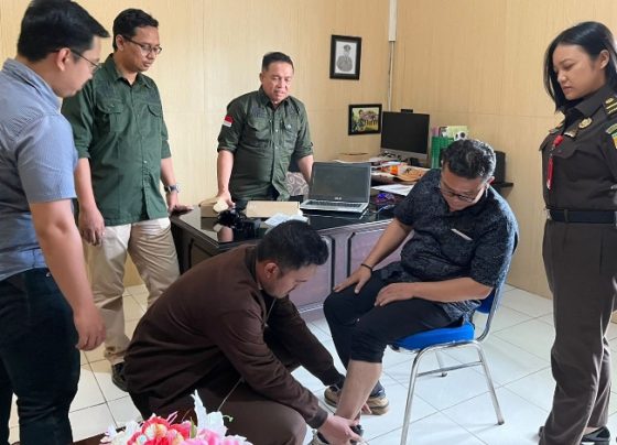 Penyidik Kejaksaan Negeri Seruyan saat memasangkan alat Detection Kit Kepada tersangka setelah berstatus tahanan kota