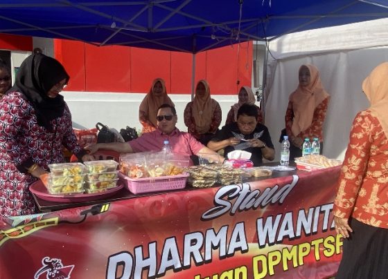 Bupati Kotim Hallikinnor saat membantu menjualkan produk UMKM di stand Dharma Wanita Persatuan DPMPTSP, Minggu, 7 Januari 2024