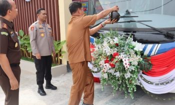 Pj Bupati Seruyan saat menyiramkan air dalam kendi ke Bus SIM Keliling yang telah resmi diluncurkan Polres Seruyan