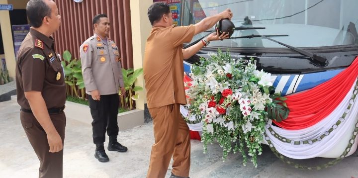 Pj Bupati Seruyan saat menyiramkan air dalam kendi ke Bus SIM Keliling yang telah resmi diluncurkan Polres Seruyan