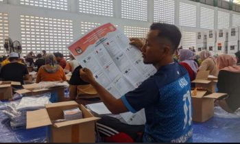 Salah seorang petugas yang ditunjuk melipat surat suara Pemilu 2024, Rabu, 3 Januari 2024