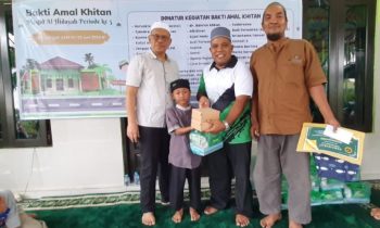 Pj Sekda Seruyan dr Bahrun Abbas bersama ketua panitia kegiatan saat menyerahkan bingkisan kepada salah seorang anak peserta khitan