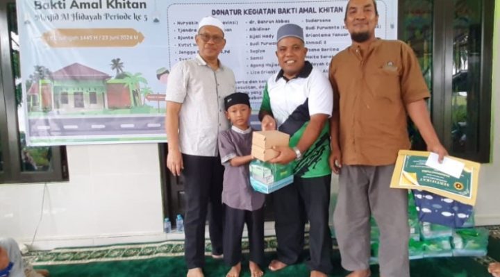 Pj Sekda Seruyan dr Bahrun Abbas bersama ketua panitia kegiatan saat menyerahkan bingkisan kepada salah seorang anak peserta khitan