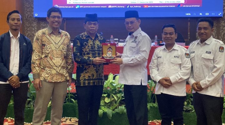 Asisten I Setda Kotim Rihel saat menerima cendra mata dari KPU Provinsi Kalteng. Senin, 1 Juli 2024