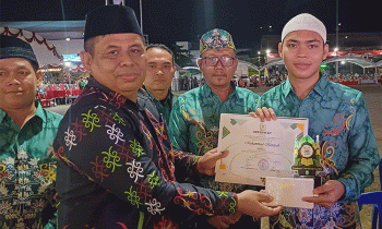 Camat Tualan Hulu Admadi Sastra menyerahkan bonus kepada Kafilah MTQ mereka, Kamis, 11 Juli 2024.