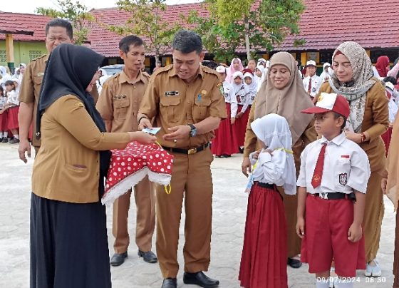 Kadisdik Kotim, M Irfansyah memberikan tanda pengenal simbolis pada pembukaan MPLS di Kecamatan Baamang, Selasa, 9 Juli 2024