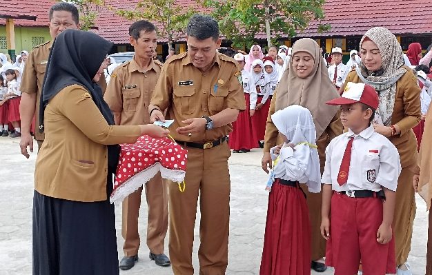 Kadisdik Kotim, M Irfansyah memberikan tanda pengenal simbolis pada pembukaan MPLS di Kecamatan Baamang, Selasa, 9 Juli 2024