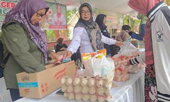 Kepala Dinas Pertanian dan Ketahanan Pangan Kotim, Septina (kemeja putih) melayani masyarakat membeli bawang putih di pasar murah, Rabu,24 Juli 2024