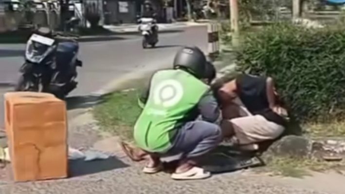 Seorang warga saat membantu korban kecelakaan di Jalan S Parman Sampit, Minggu, 14 Juli 2024