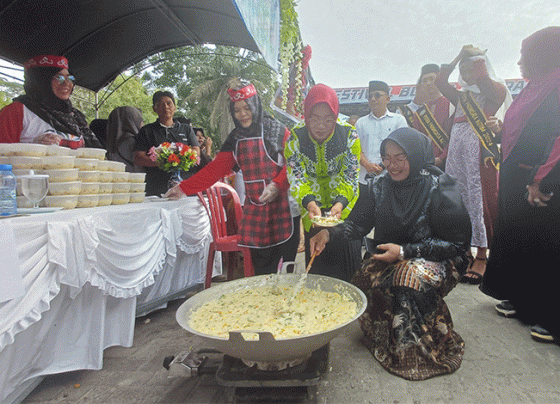 Wakil Bupati Kotawaringin Timur Irawati dan Ketua TP PKK Khairiah Halikinnor menyajikan bubur asyura di Taman Kota Sampit, Minggu, 21 Juli 2024.