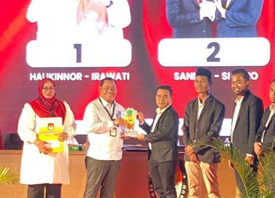 Pasangan Halikinnor Irawati atau Harati menerima cindra mata dari Ketua KPU Kotim M Rifqi, Senin malam, 23 September 2024.