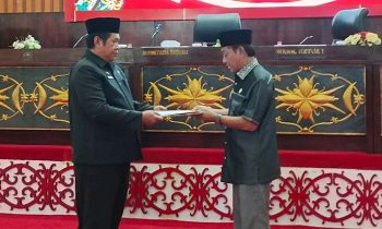 Penjabat (Pj) Sekretaris Daerah (Sekda) Murung Raya Rudie Roy saat menyerahkan Raperda tentang RAPBD perubahan tahun 2024 kepada Wakil Ketua I DPRD Murung Raya Likon di Gedung DPRD Murung Raya, Selasa.