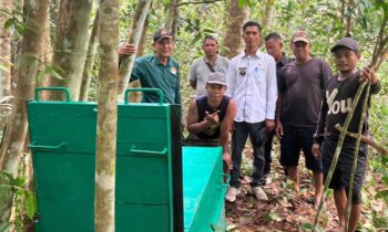 Komandan BKSDA Resort Sampit Muriansyah dibantu warga Desa Rawa Sari memasang perangkap beruang, Rabu, 16 Oktober 2024.