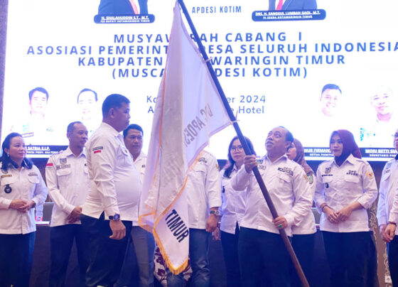 Plt DPC APDESI Kotim Aswin Nur menyerahkan bendera APDESI kepada Damastius yang terpilih menjadi Pimpinan Defenitif DPC APDESI Kotim, Kamis, 31 Oktober 2024.