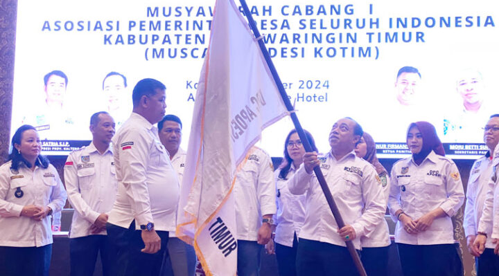 Plt DPC APDESI Kotim Aswin Nur menyerahkan bendera APDESI kepada Damastius yang terpilih menjadi Pimpinan Defenitif DPC APDESI Kotim, Kamis, 31 Oktober 2024.