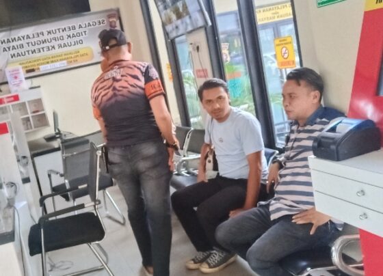 Rusli (duduk baju garis garis) saat membuat laporan di SPKT Polres Kotim.