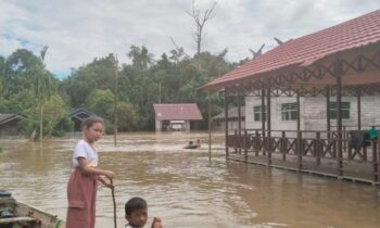 Sejumlah anak anak saat menggunakan perahu ketika menuju sekolah yang di landa banjir di Desa Tumbang Gagu, Kecamatan Antang Kalang, Kabupaten Kotim