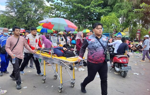 Tim medis saat mengevakuasi peserta jalan sehat yang pingsan.