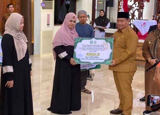 Bupati Kotim didampingi Wakil Bupati Kotim saat menyerahkan bonus kepada yang juara di lomba MTQH, Senin, 16 Desember 2024.