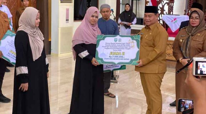 Bupati Kotim didampingi Wakil Bupati Kotim saat menyerahkan bonus kepada yang juara di lomba MTQH, Senin, 16 Desember 2024.