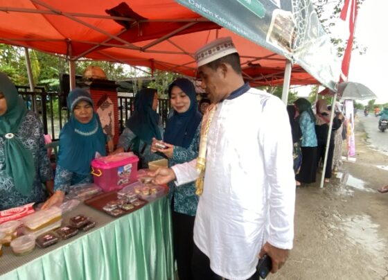 Lurah Baamang Hulu, Rudi Setiawan didampingi Ketua PKK kelurahan saat berbelanja menu buka puasa di Pasar Ramadan Baamang Hulu, Minggu, 1 Maret 2025