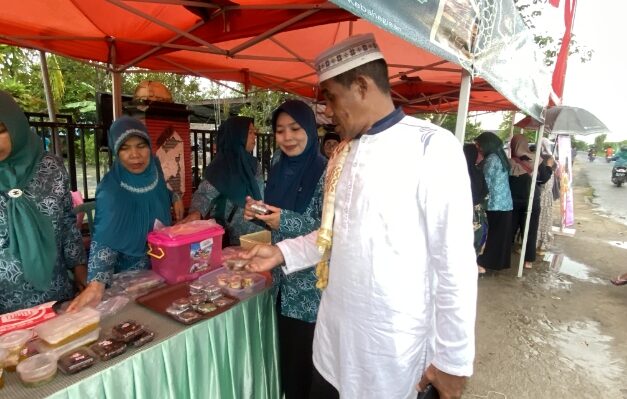 Lurah Baamang Hulu, Rudi Setiawan didampingi Ketua PKK kelurahan saat berbelanja menu buka puasa di Pasar Ramadan Baamang Hulu, Minggu, 1 Maret 2025